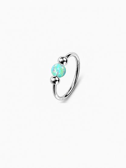 Silver G23 titanium seamless clicker ring featuring a glowing green opal center bead