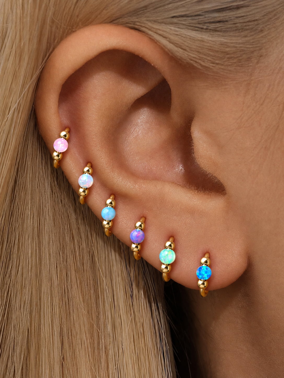 Colorful opal G23 titanium seamless clicker rings styled together in a curated ear stack