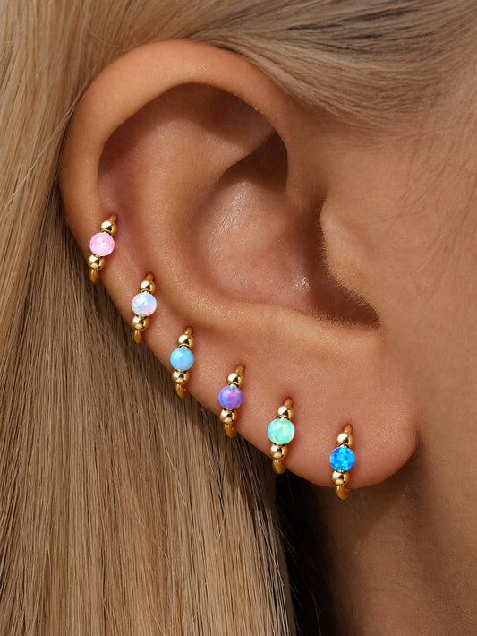 Colorful opal G23 titanium seamless clicker rings styled together in a curated ear stack