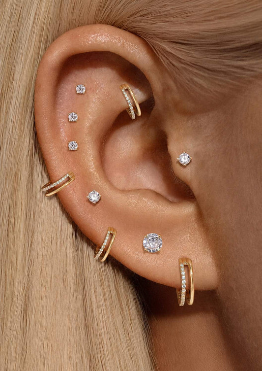 Gold crystal clicker hoop earrings styled in a curated lobe, helix and cartilage ear stack.