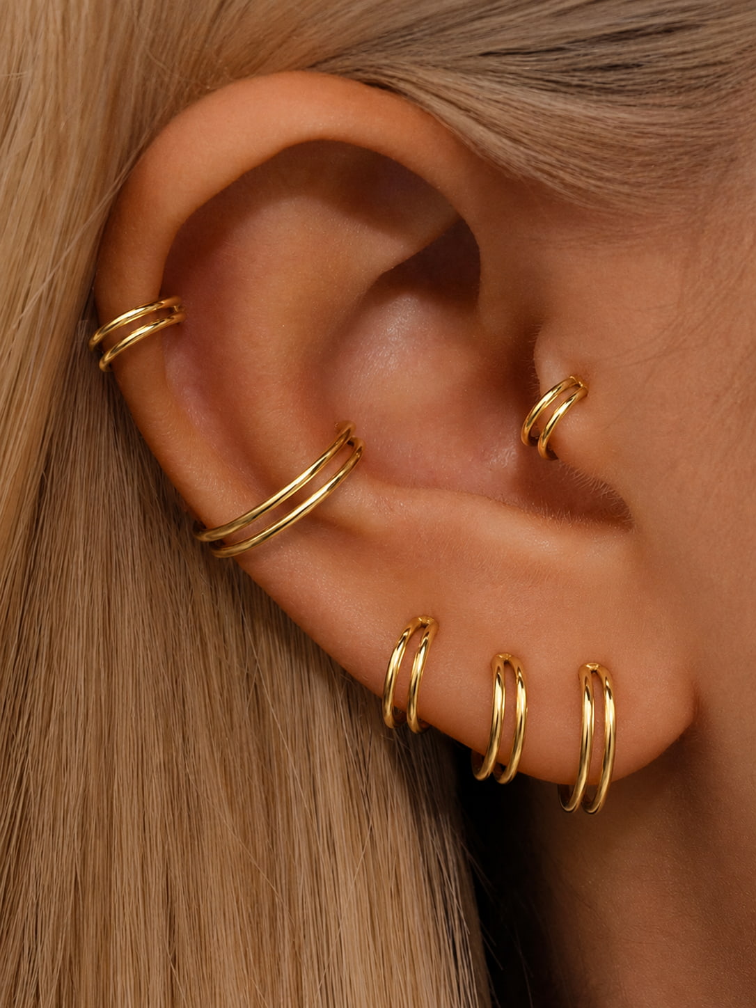 Gold double hoop clicker rings styled on helix conch lobe and tragus piercings