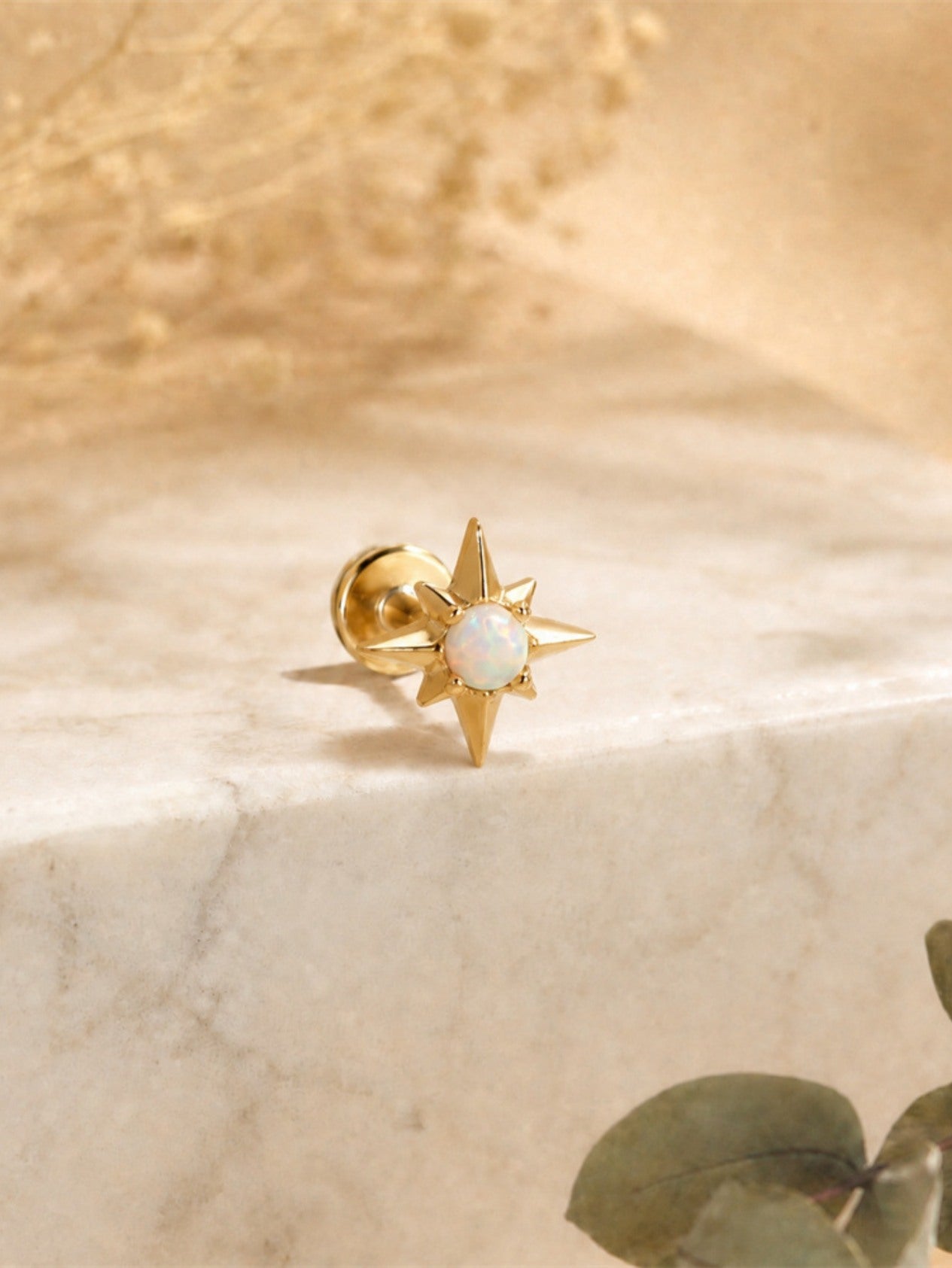 Gold opal star flat back earring displayed on marble background