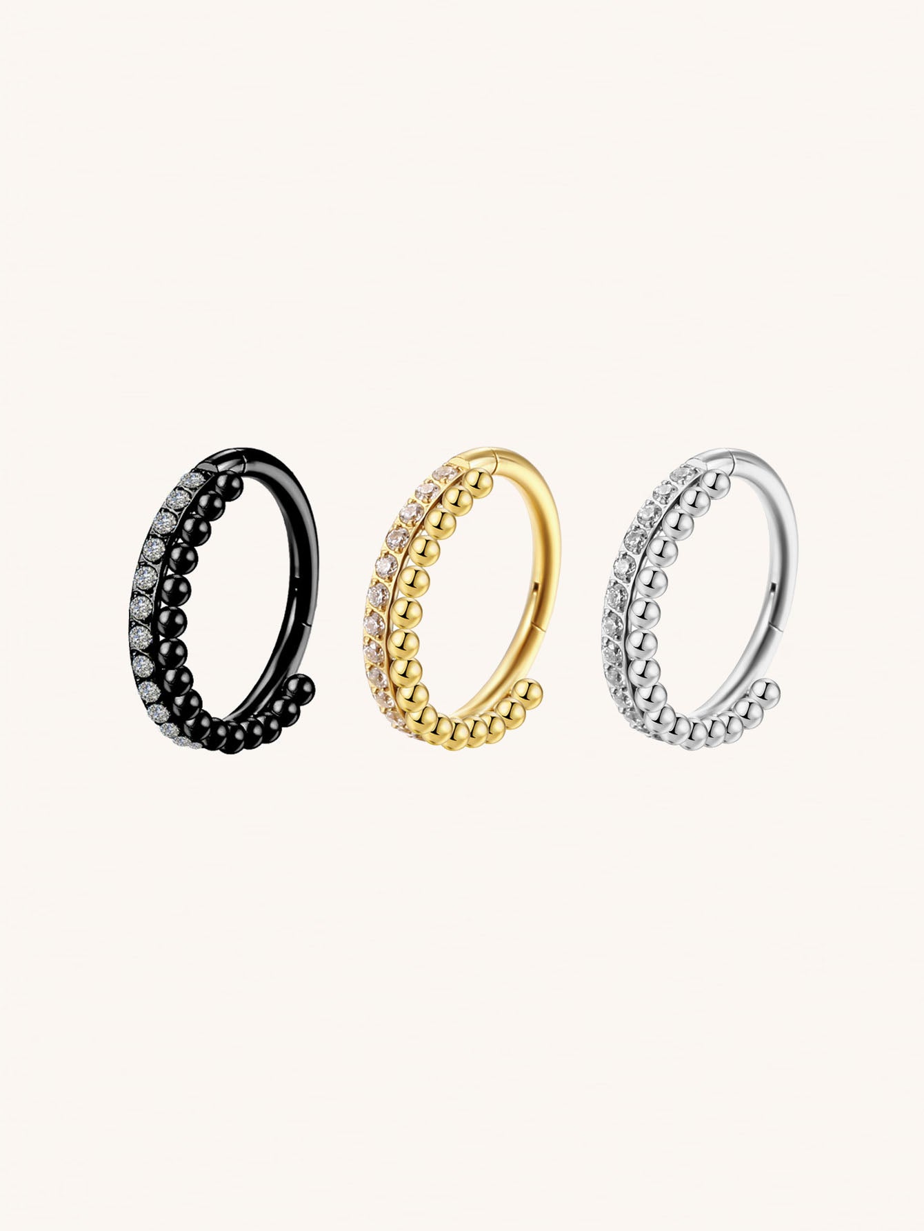 Gold silver and black CZ beaded clicker hoop rings on beige background