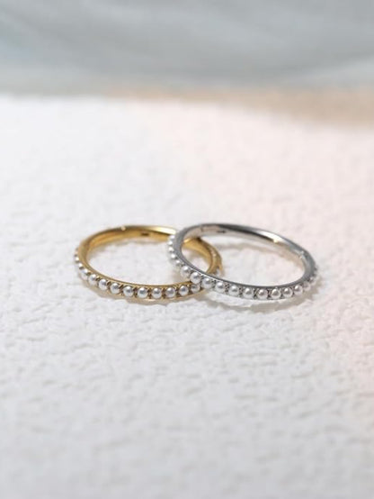 Gold and silver freshwater pearl clicker hoops on soft textured background