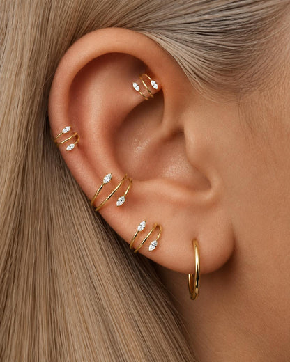 Gold double spiral clicker hoop styled in helix conch and lobe piercings