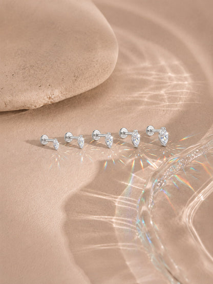 Marquise moissanite flat back studs in five sizes on a warm neutral background