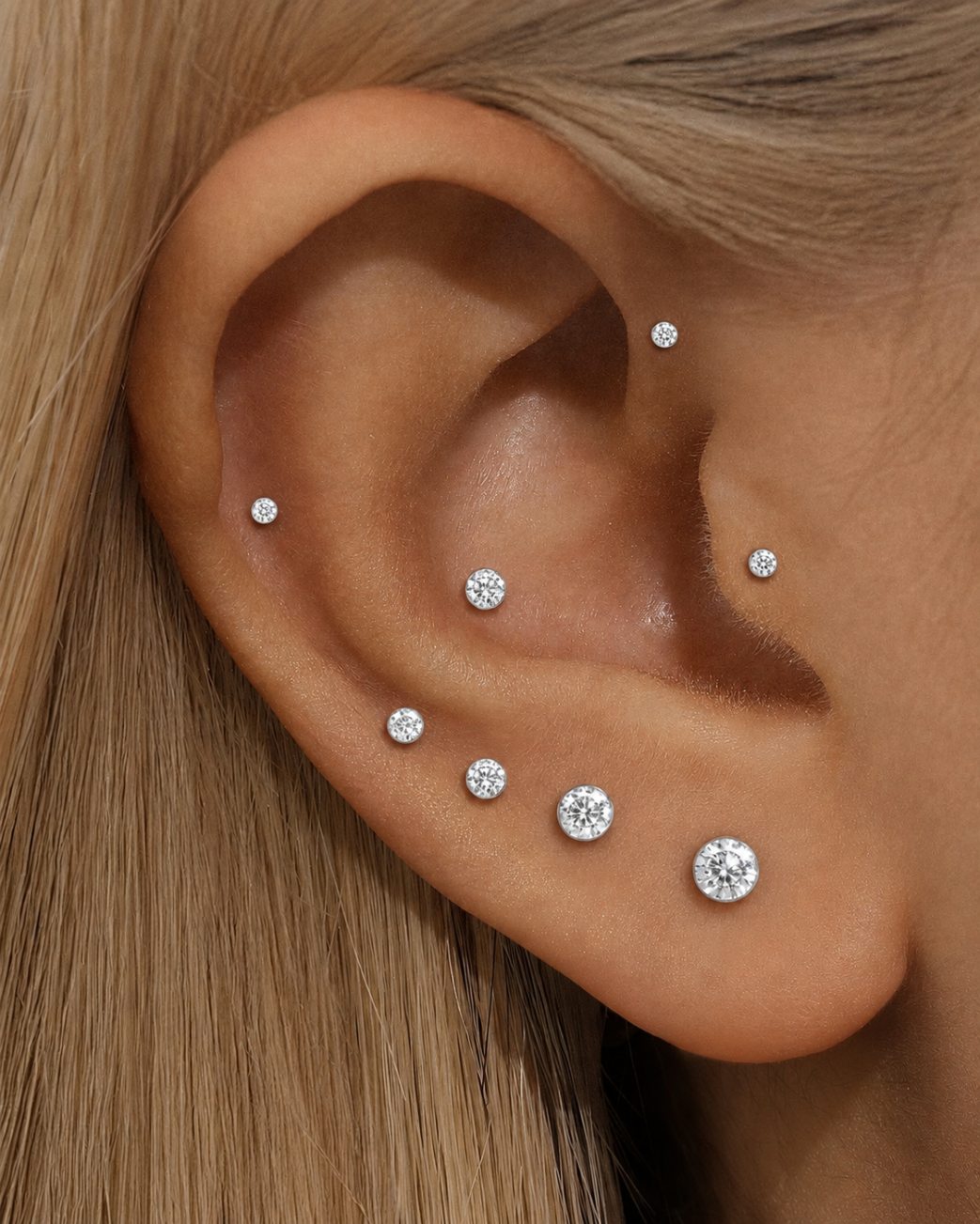 Moissanite flat back studs in multiple sizes worn on lobe and cartilage piercings