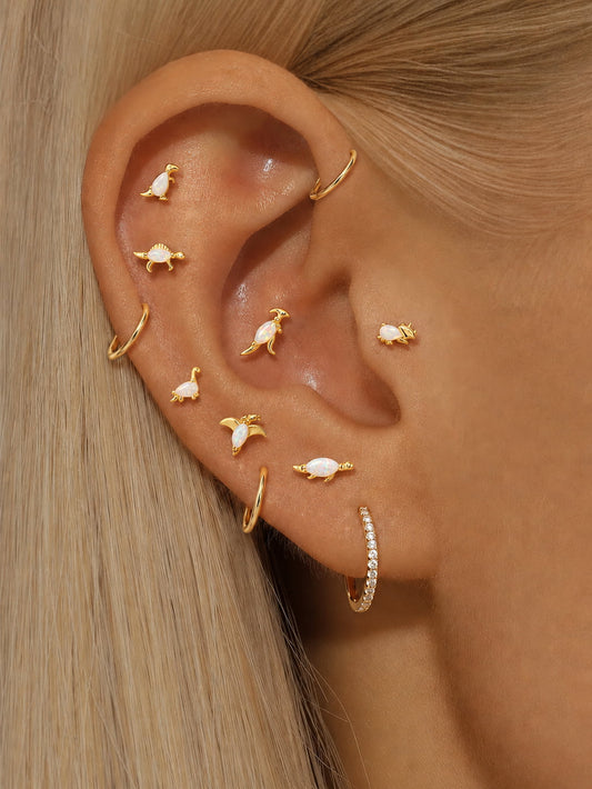 Opal dinosaur sterling silver earrings styled in a curated cartilage ear stack