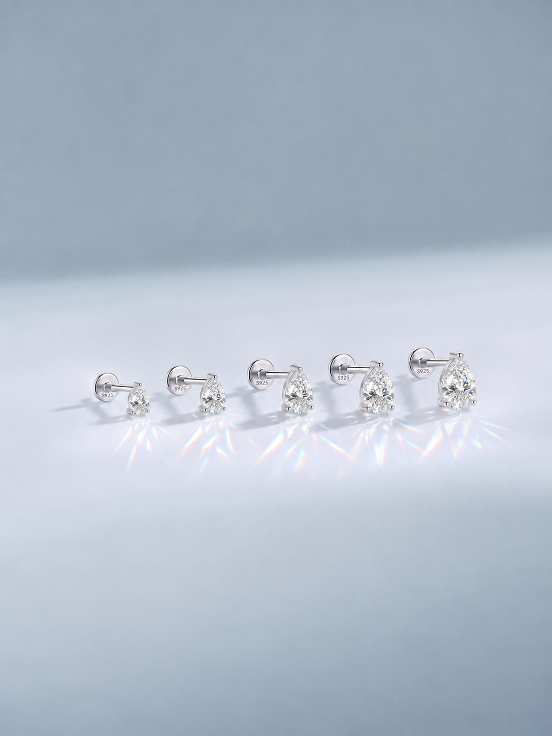 Pear-cut moissanite sterling silver flat back studs in five graduated sizes