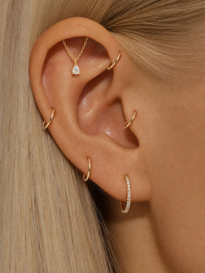 Gold pear drop hidden helix earring styled on upper ear