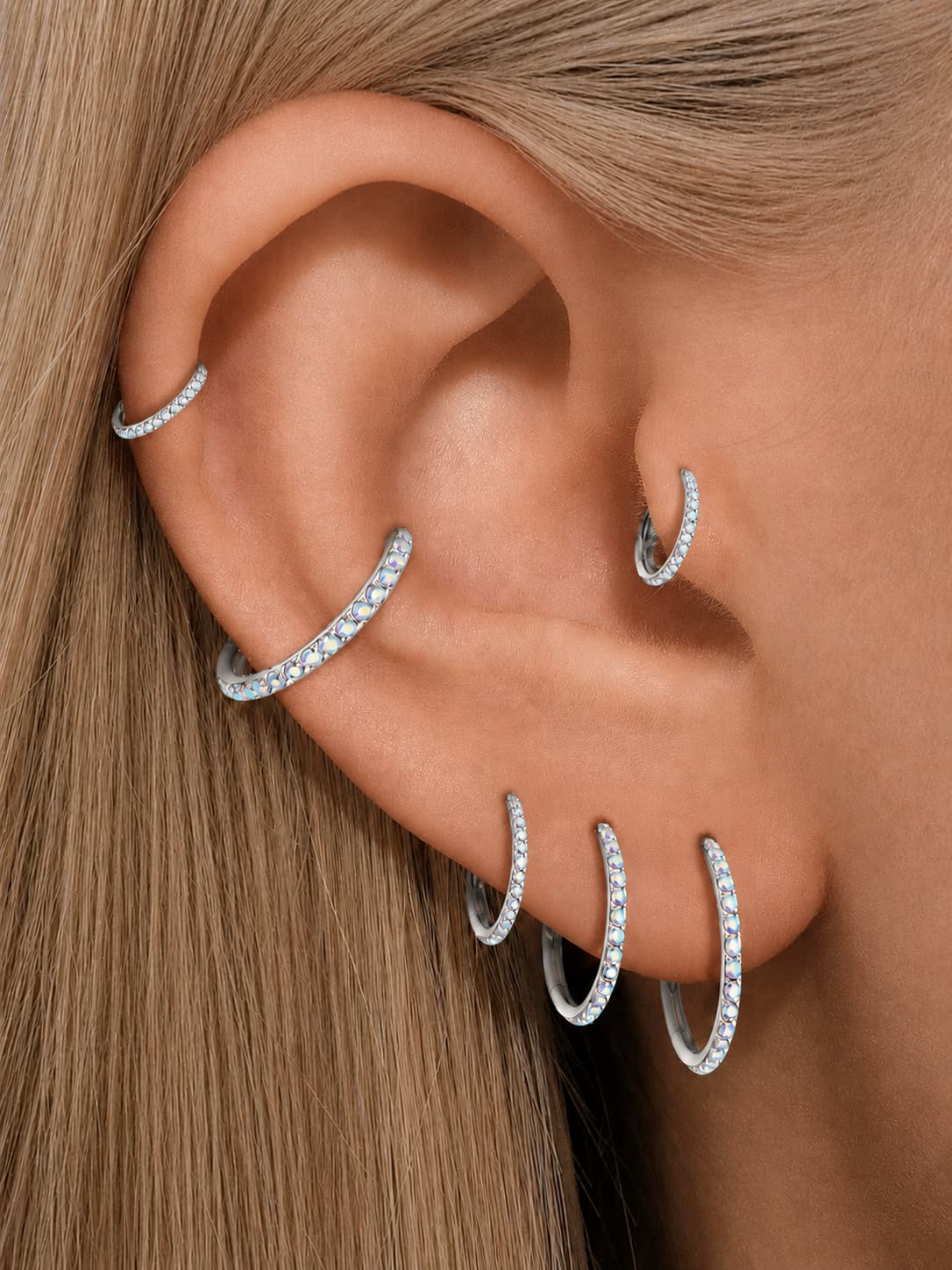 Silver G23 titanium AB zirconia clicker hoops styled on helix conch lobe and tragus piercings