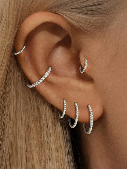 White opal titanium clicker hoops styled in a curated ear stack
